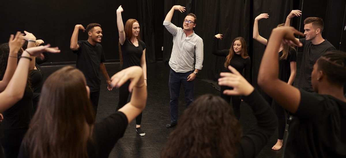 Eine Theatergruppe aus Schülern und Lehrer machen Bewegungsübungen mit den Armen, Foto: Colourbox