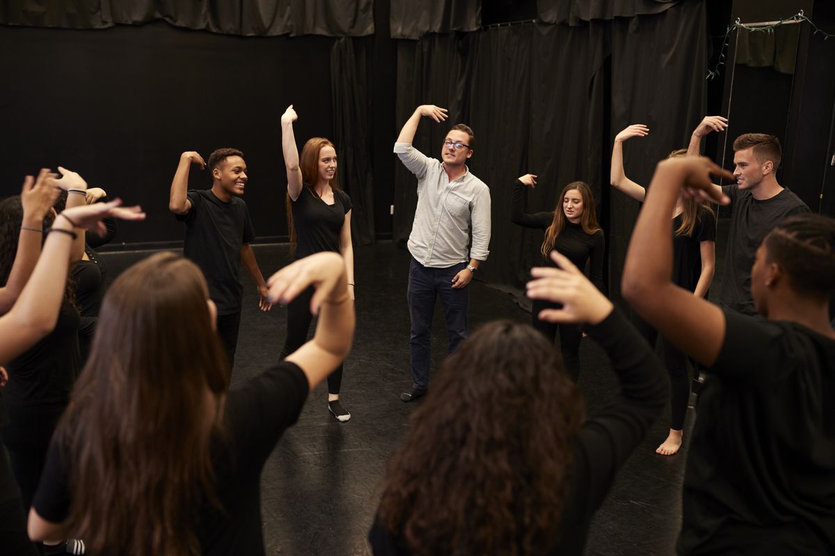 zur Vergrößerungsansicht des Bildes: Eine Theatergruppe aus Schülern und Lehrer machen Bewegungsübungen mit den Armen, Foto: Colourbox