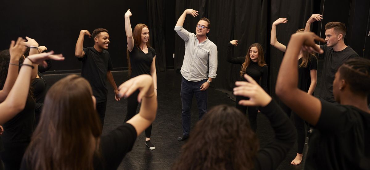 Eine Theatergruppe aus Schülern und Lehrer machen Bewegungsübungen mit den Armen, Foto: Colourbox