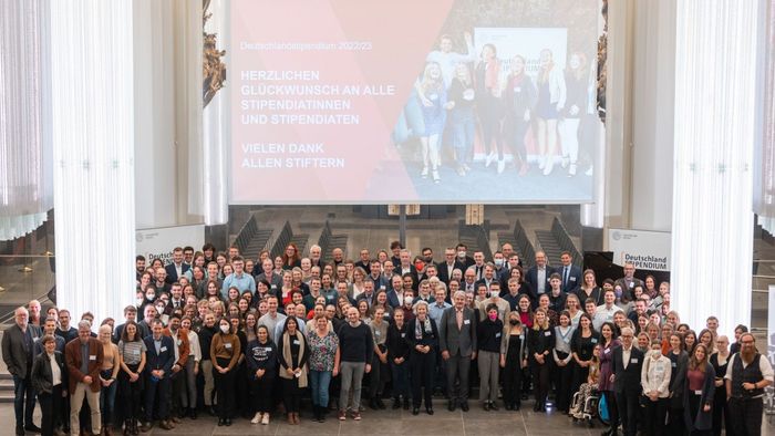 alle Stipendiaten und Förderer stehen auf der Bühne in der Aula im Paulinum und schauen hoch zum Fotografen für ein Gruppenbild