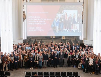 alle Stipendiaten und Förderer stehen auf der Bühne in der Aula im Paulinum und schauen hoch zum Fotografen für ein Gruppenbild