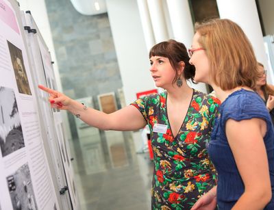 Foto: zwei Frauen stehen an einer Schautafel und informieren sich