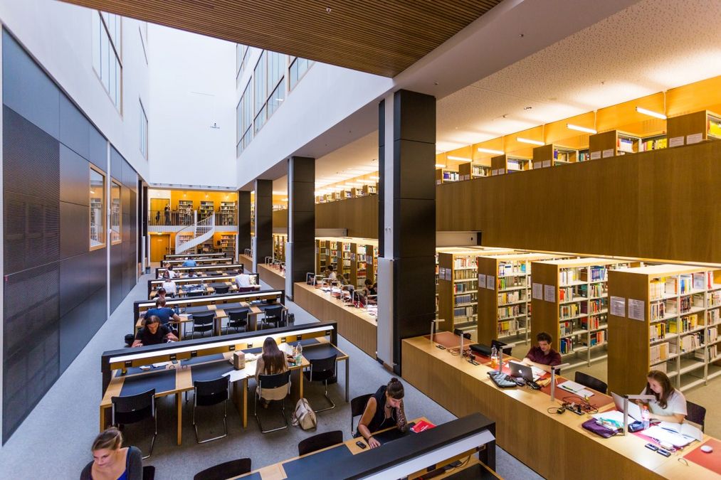 zur Vergrößerungsansicht des Bildes: Innenansicht der untersten Ebene der Campusbibliothek mit Blick auf die belegten Arbeitsplätze