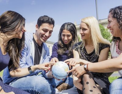 International students point at globe