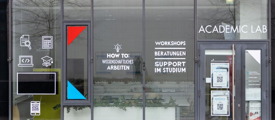 Außenansicht Leibniszladen mit Icons und Fenstergestaltung zum Angebot des Academic Labs, Foto: Academic Lab/Andy Plötz