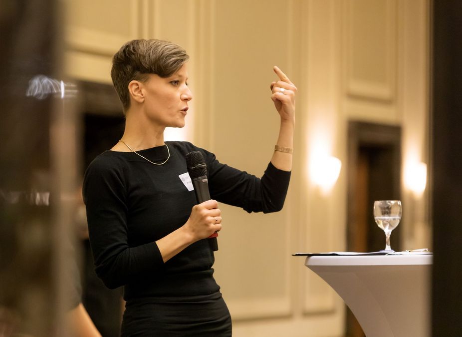 zur Vergrößerungsansicht des Bildes: Foto: Dr. Sabrina Walter ist während ihres Vortrag im Profil zu sehen, mit erhobenem Arm. Foto: Swen Reichhold