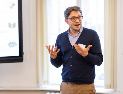 Das Foto zeigt einen Postdoc-Wissenschaftler der Medizinischen Fakultät, Dr. Lars White, der gerade einen Vortrag hält.