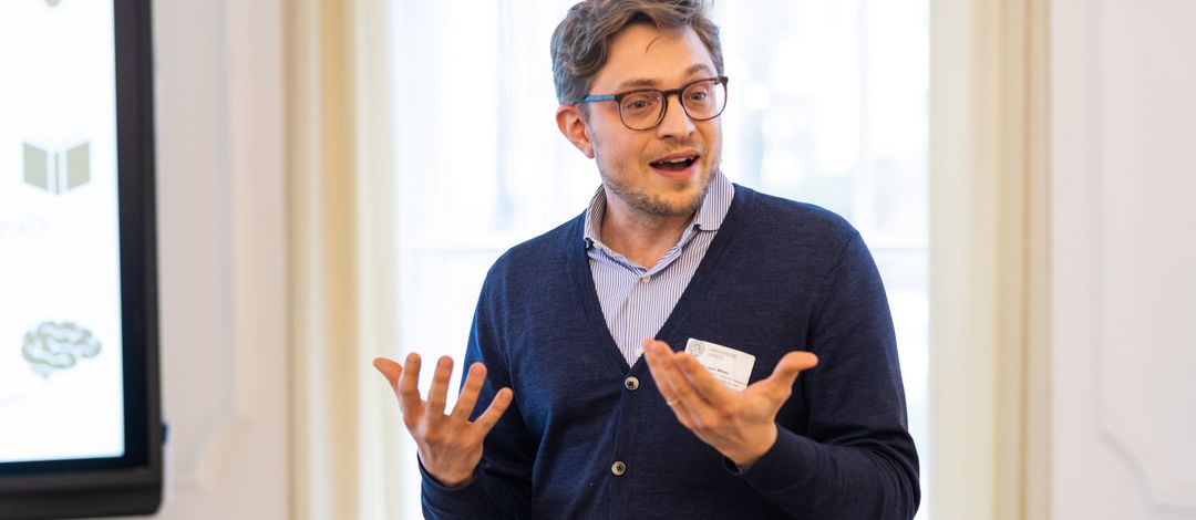 Das Foto zeigt einen Postdoc-Wissenschaftler der Medizinischen Fakultät, Dr. Lars White, der gerade einen Vortrag hält.