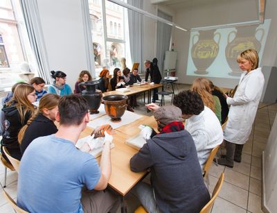 Foto: Studierende sitzen im Seminar und untersuchen verschiedene Materialien