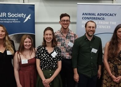 Mitglieder der Arbeitsgruppe Kinder und Natur, Foto: Prof. Dr. Katja Liebal Sechs Personen stehen vor Bannern in einem Konferenzumfeld