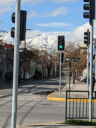 Eine Straße mit bunten Häusern, im Hintergrund schneebedeckte Berge bei Tag 