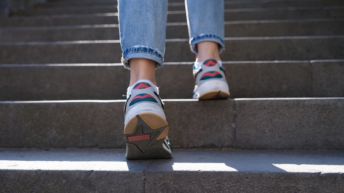 Füße in Sportschuhen steigen eine Treppe hinauf