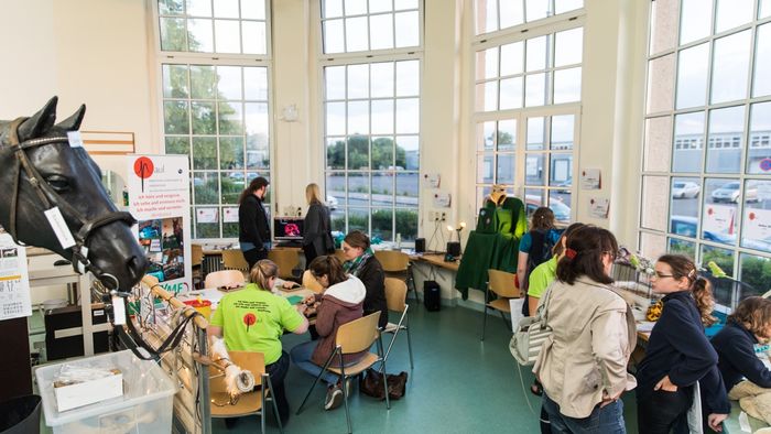 mehrere Personen sitzen verteilt in einem Studierzimmer und unterhalten sich in kleinen Gruppen