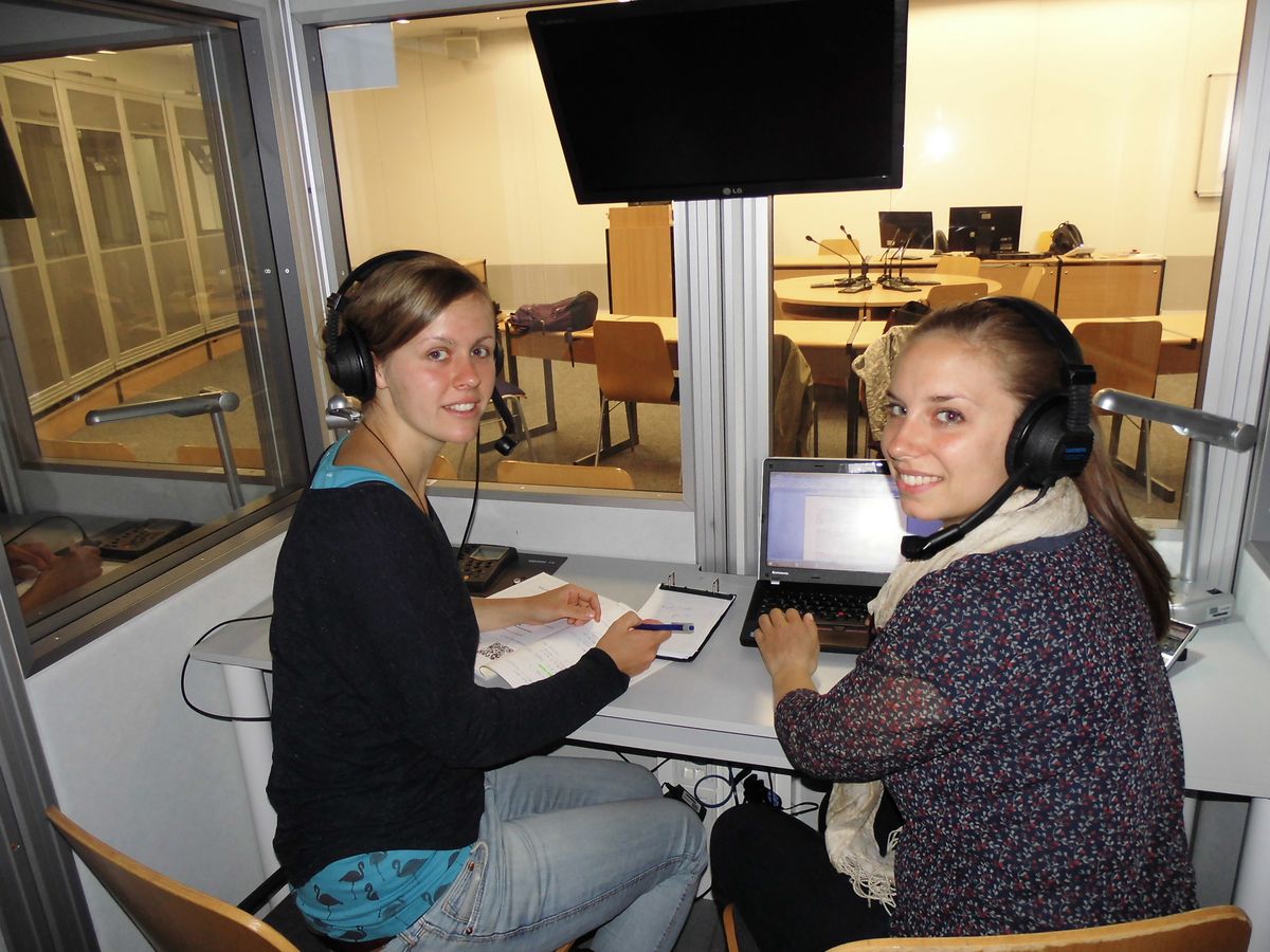 zur Vergrößerungsansicht des Bildes: In der Dolmetschtrainingsanlage mit Andrea Röher und Petra Riesiger, die nebeneinander sitzen, Foto: Universität Leipzig