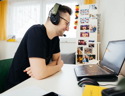 Mann trägt Headset und nimmt an einer Videoberatung teil, Foto: Christian Hüller