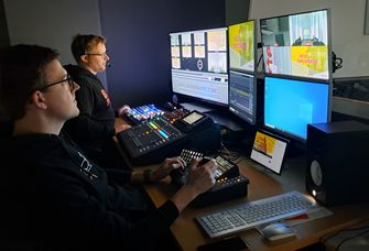 Zu sehen ist die neue Bildregie: zwei Techniker sitzen vor Monitoren, die mehrere Kameraperspektiven zeigen, und einem Mschpult.
