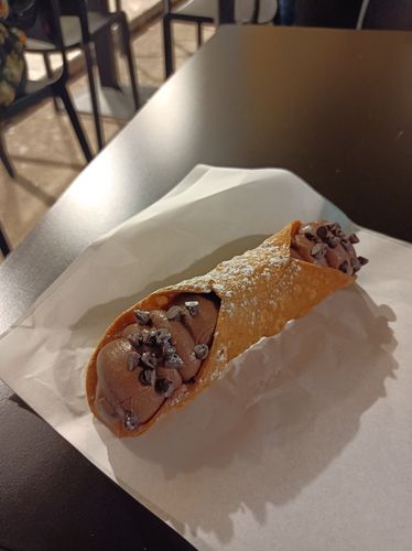 Gefüllte Cannoli (Keksrolle) mit Schokolade auf Tisch bei Tageslicht