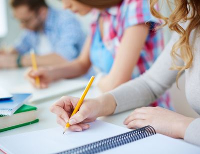 Studierende schreiben in der Vorlesung mit. Foto: Colourbox