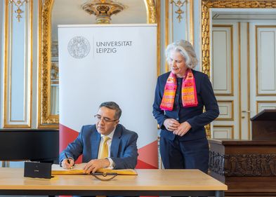 The Ambassador of India to Germany, Ajit Vinayak Gupte, signed Leipzig University’s Golden Book. Standing beside him is Rector Professor Eva Inés Obergfell. Photo: Swen Reichhold Zu sehen ist sitzend und ins Goldene Buch der Uni Leipzig schreibend der Botschafter Indiens in Deutschland, Ajit Vinayak Gupte. Neben ihm steht Rektorin Prof. Dr. Eva Inés Obergfell. Foto: Swen Reichhold