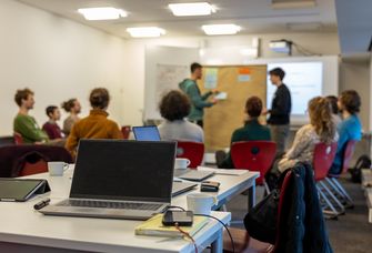 Seminarsituation mit mehreren Studierenden, im Vordergrund ein Laptop.