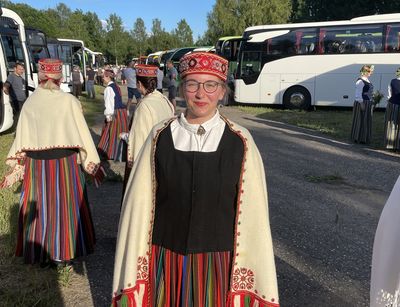 Bild in einem finnischen Chorgewand vor dem Konzert zwischen Bussen und Menschen