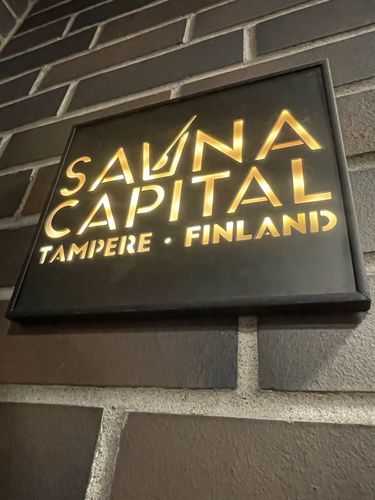 Auf dem Bild ist ein Schild einer Sauna zu sehen. Auf dem Schild steht Sauna Capital Tampere Finnland.