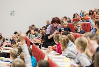 Kinder beantworten eine Frage bei der Kinderuni im Audimax