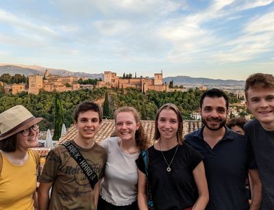 Gruppenfoto mehrerer Menschen in Granada, im Hintergrund die Al Hambra