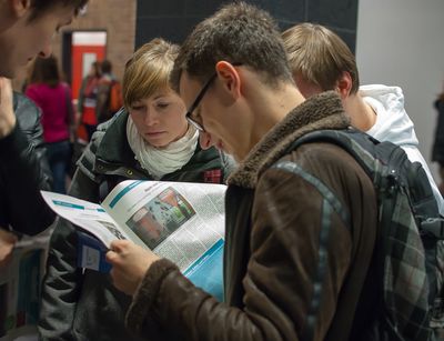 Foto: Studierende lesen in der Hochschulzeitung