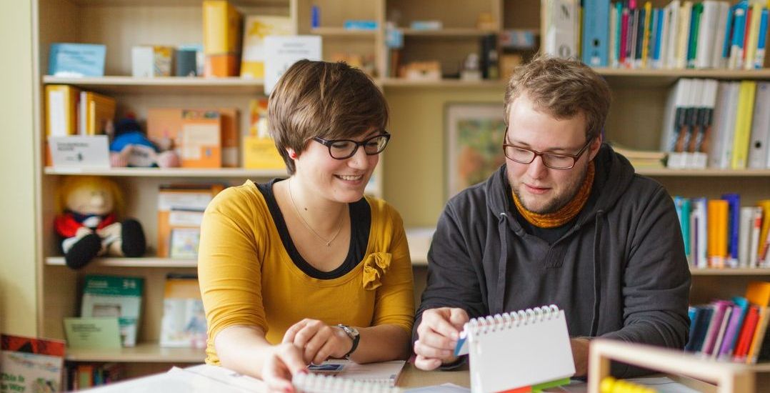 Studentin und Student sitzen in der Lernwerkstatt beisammen und schauen sich Material an, Foto: Christian Hüller