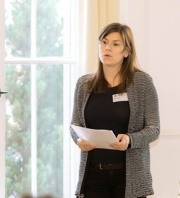 zur Vergrößerungsansicht des Bildes: Dr. Christiane Klein steht vor dem Publikum und stellt Angebote zur Forschungsförderung vor.