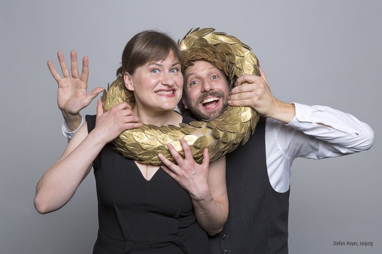 Foto von zwei Kabarettisten die ihre Köpfe durch einen Siegeskranz stecken.