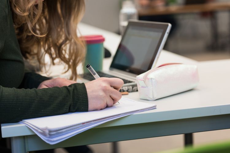 Nahaufnahme auf Studentin, die eine Mitschrift im Seminar anfertigt, Foto: Christian Hüller