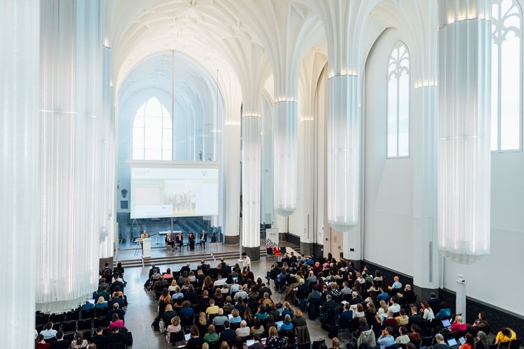 Zu sehen ist eine Tagung, mit Vortrag und Publikum im Paulinum, von oben fotografiert.