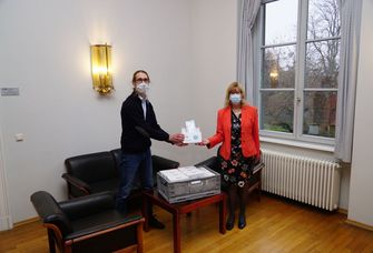 Linus Schlüter übergibt die Maskenspende an Dr. Nicola Klöß.