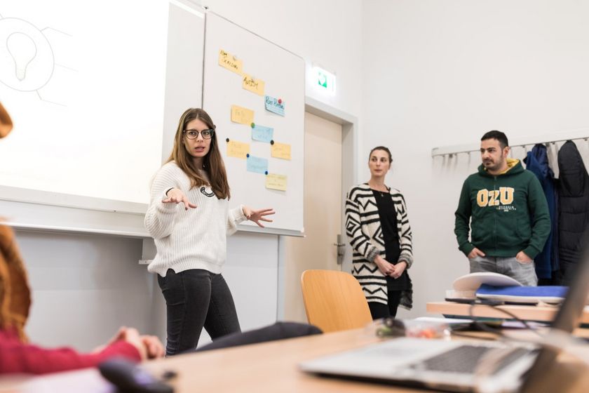 Eine Studentin erklärt ihr Thema vor einer Gruppe Studierender im Seminar, Foto: Christian Hüller