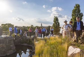 Mitglieder der Universitätsgesellschaft stehen an Teich im Wörlitzer Park