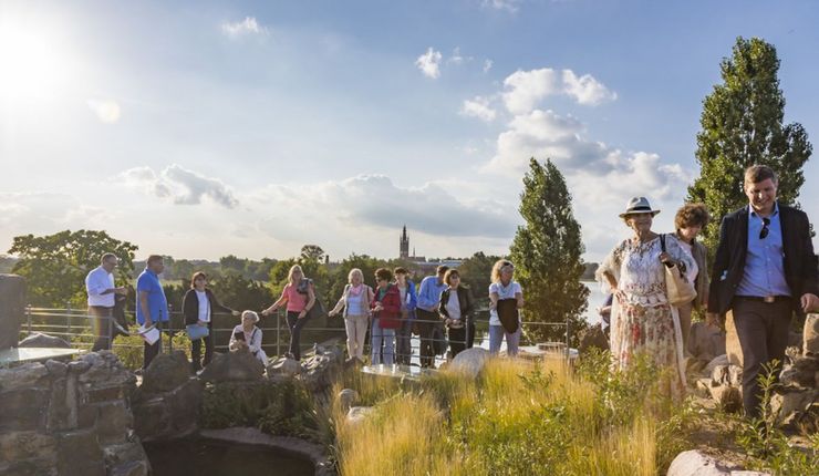 Mitglieder der Universitätsgesellschaft stehen an Teich im Wörlitzer Park