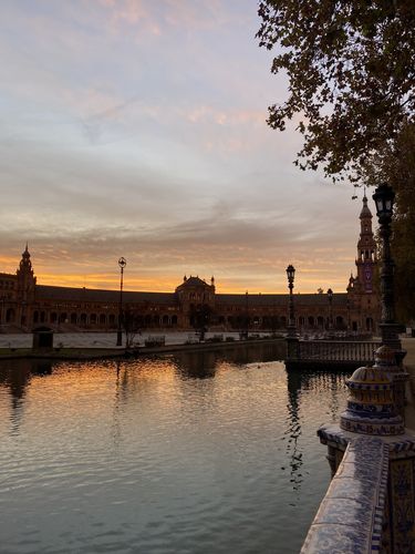 Der Plaza mit Wassergraben im Vordergrund und Schloss im Hintergrund bei Abenddämmerung.