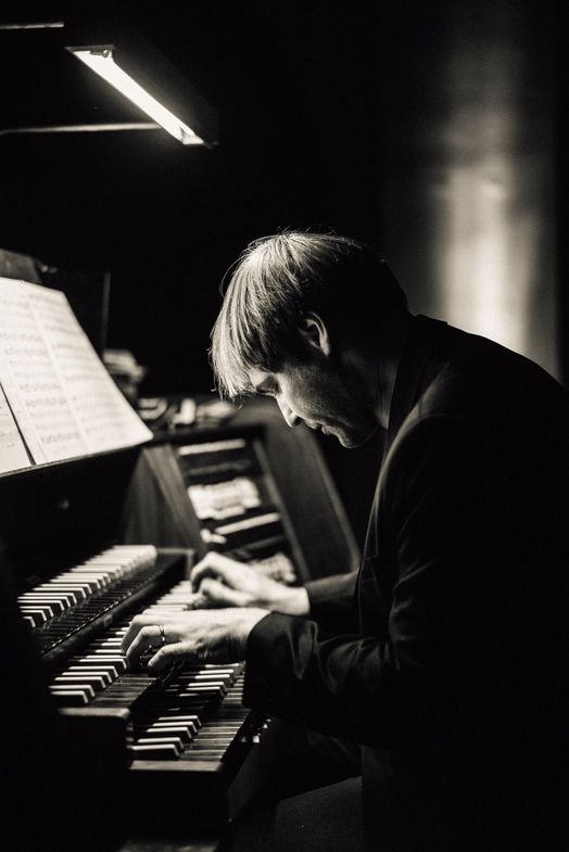Schwarz-Weiß-Fotografie von Daniel Beilschmidt an seiner Orgel sitzend und spielend