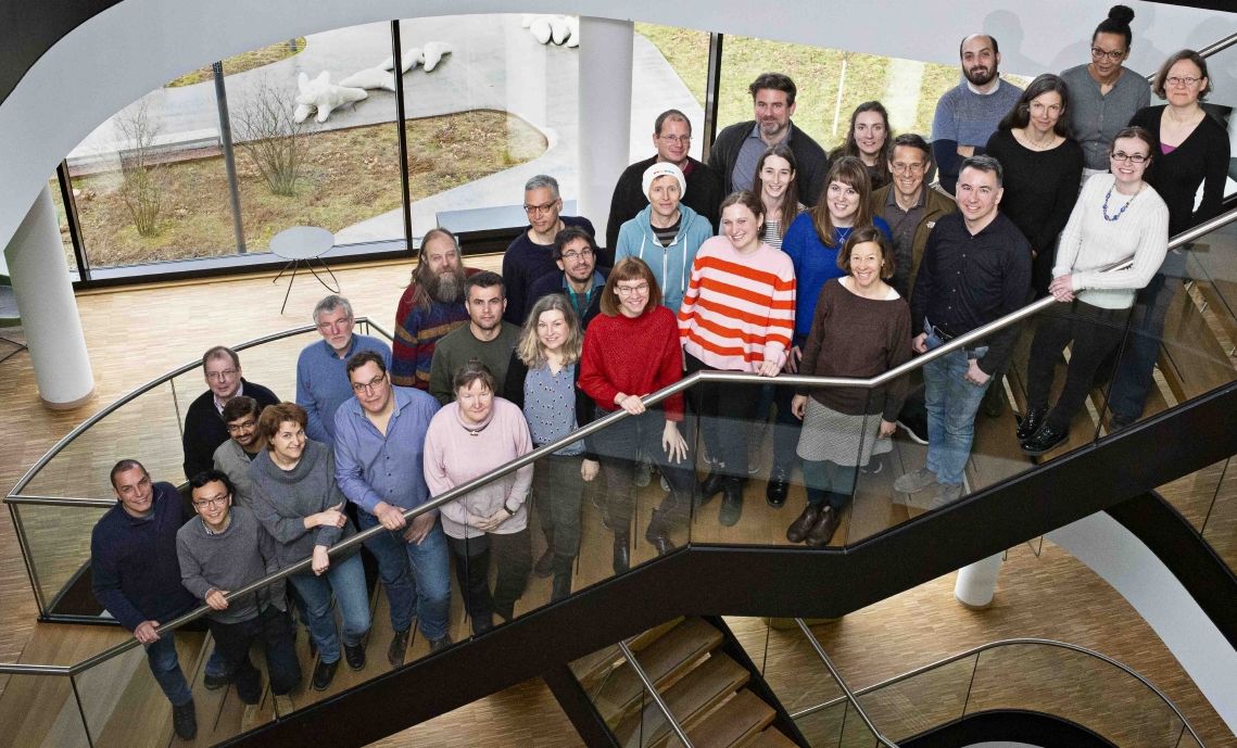 zur Vergrößerungsansicht des Bildes: Farbfoto: Vogelperspektive auf eine Gruppe von Menschen, die auf einer Treppe stehen