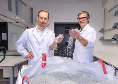 Photo: Swen Reichhold, Leipzig University Dr. Ronny Frank und Dr. Christian Sonnendecker stehen vor einem Sack voll kleingehäckselten Plastikteilen.