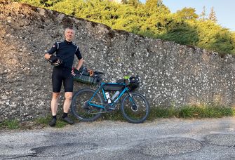 Professor Beat Siebenhaar steht neben seinem Rennrad am Straßenrand.