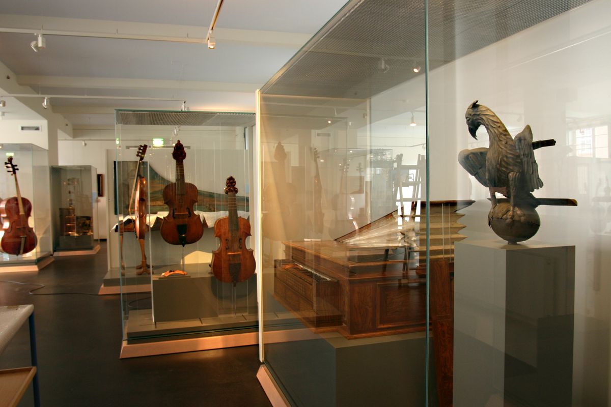 enlarge the image: Verschiedene historische Streich- und Tasteninstrumente stehen in dem gezeigten Ausstellungsraum.