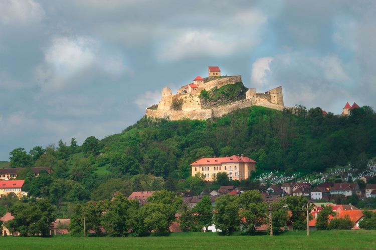 Zu sehen ist eine mittelalterliche Burg auf einem Hügel.