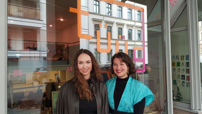 Studentinnen vor einer Schaufensterscheine mit dem Schriftzug "tüüg"