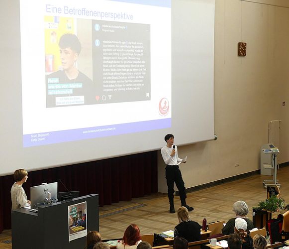 Noah Dejanovic während eines Vortrags im vollen Hörsaal vor Lehramtsstudierenden zum Thema Kindesmissbrauch