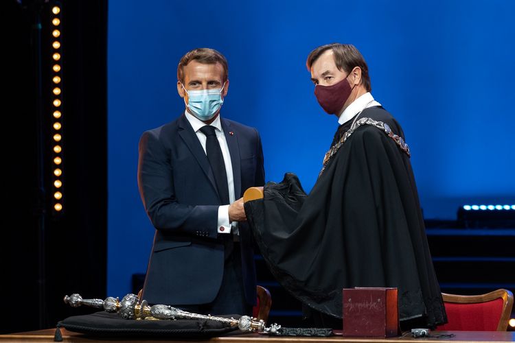 Emmanuel Macron bekommt das Ehrendiplom feierlich überreicht.