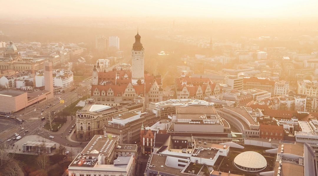 Das Bild zeigt Leipzig von oben, mit dem Neuen Rathaus im Hintergrund. 