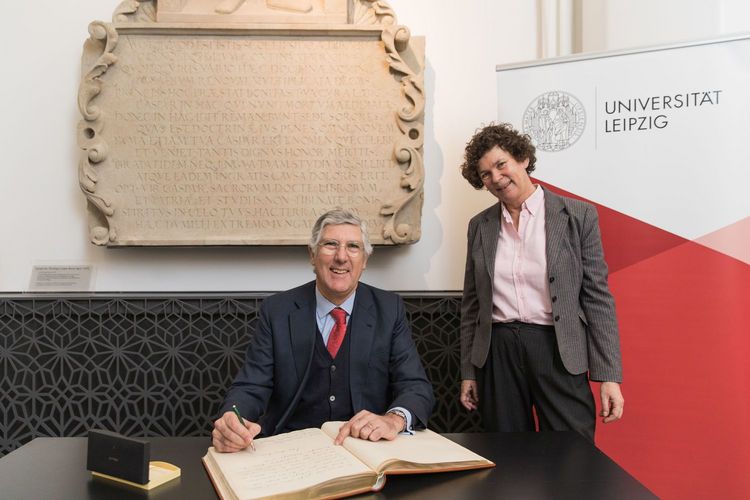 Der Botschafter Portugals, João Mira Gomes - hier mit Rektorin Prof. Dr. Beate Schücking - trägt sich ins Goldene Buch der Universität Leipzig ein.